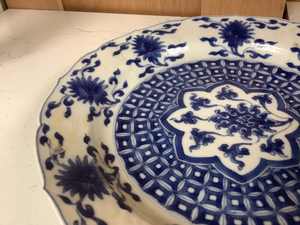 A pair of Chinese blue and white porcelain plates, Kangxi mark and period, with shaped borders and floral motifs, diameter 20cm